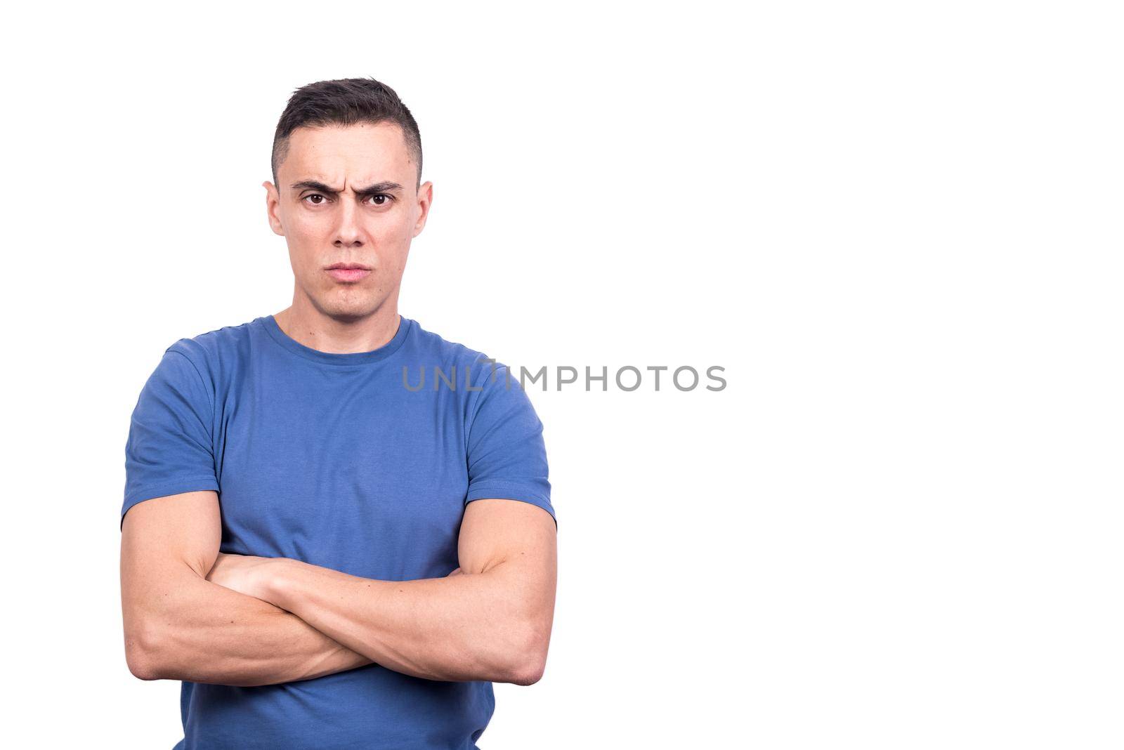 Studio portrait with white background of a man with arms crossed and angry expression