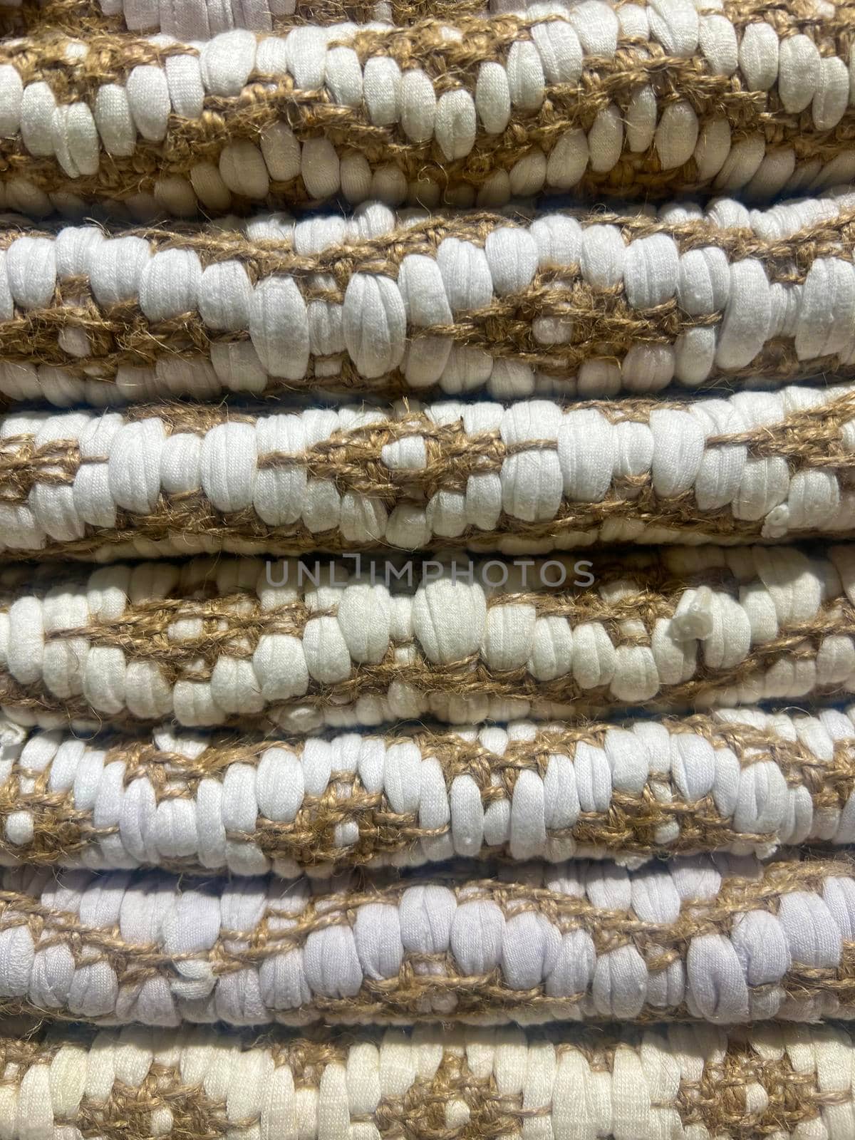Background of bright early-colored fragments of hand-knitted floor rugs traditional scandinavian folk craft. knitted carpet texture close up. natural knitted fabric, folded. High quality photo
