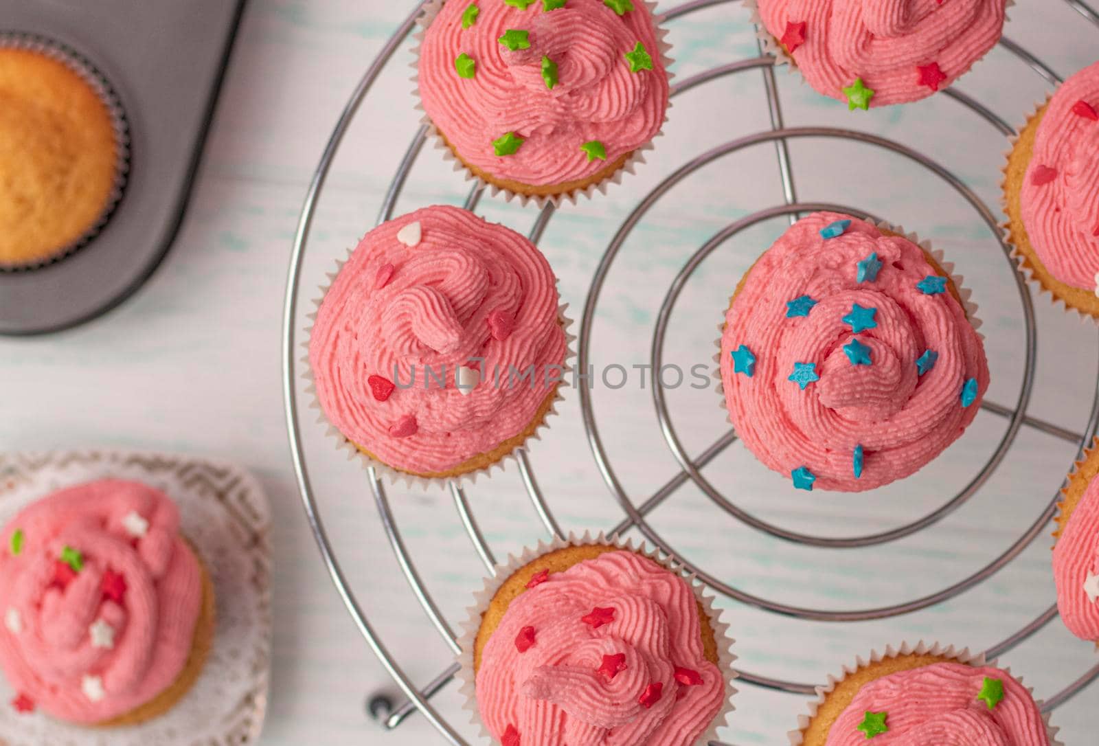 top view, vanilla muffins decorated with cream and sugar multicolored decor. stand in a circle. Homemade baking concept. Beautifully decorated cupcakes with butter cream. High quality photo