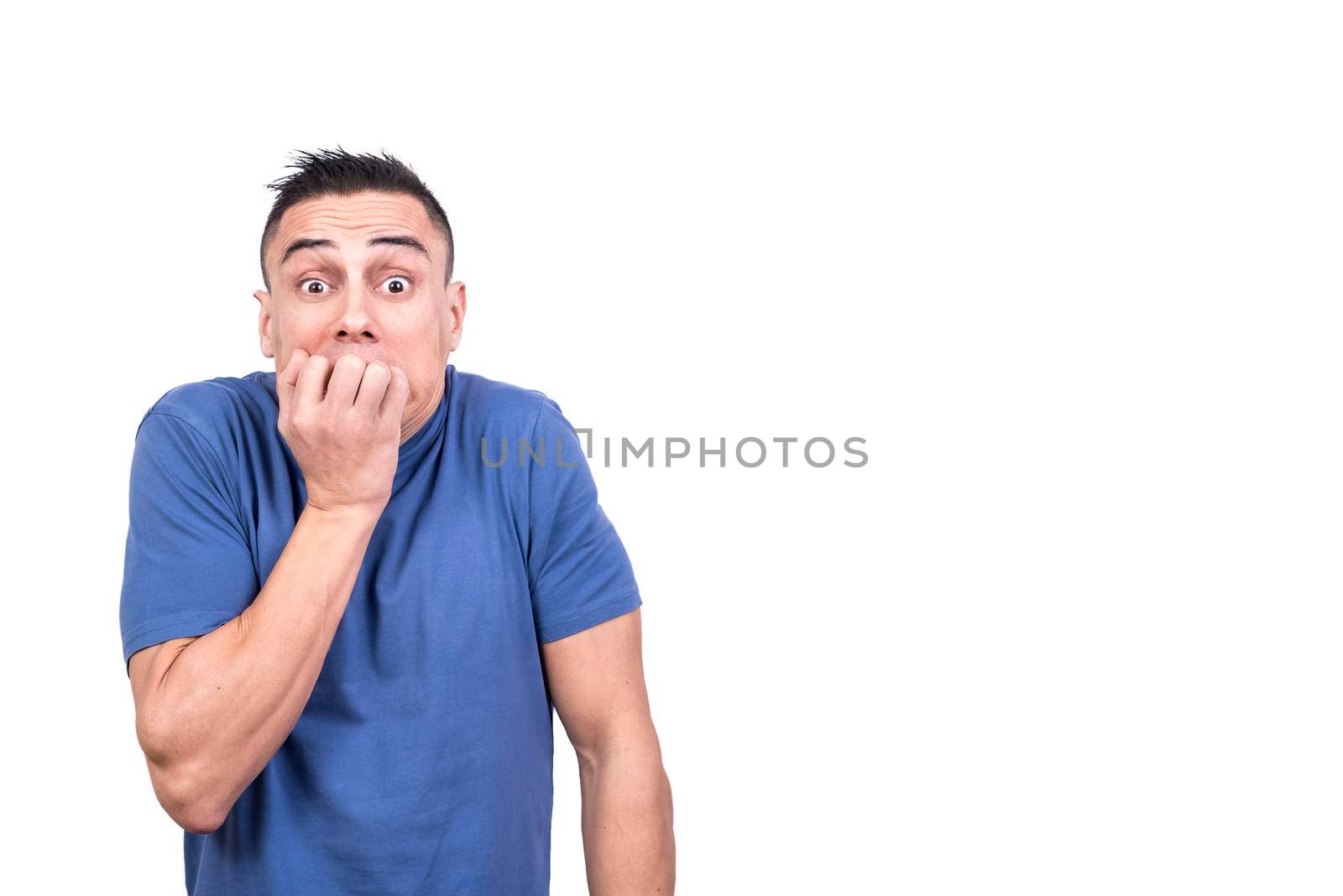 Studio portrait with white background of a man biting his nails with frightened expression