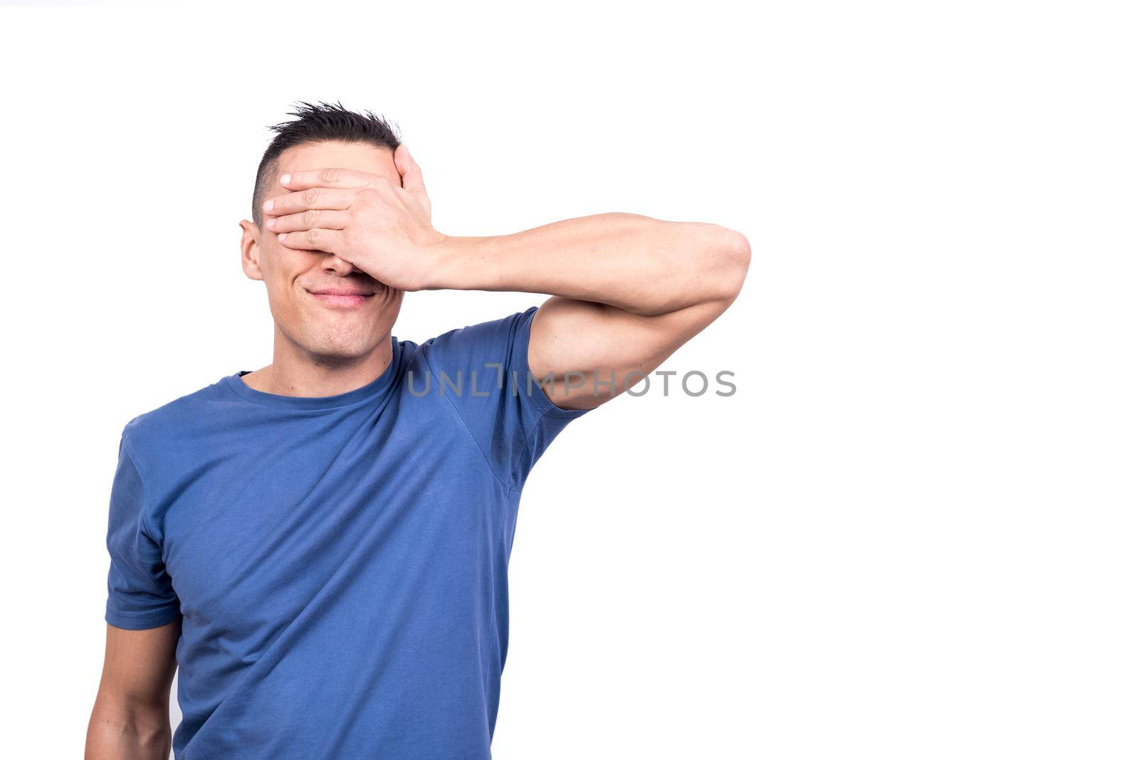 Studio photo with white background of a man covering his eyes with his hand to keep out of sight