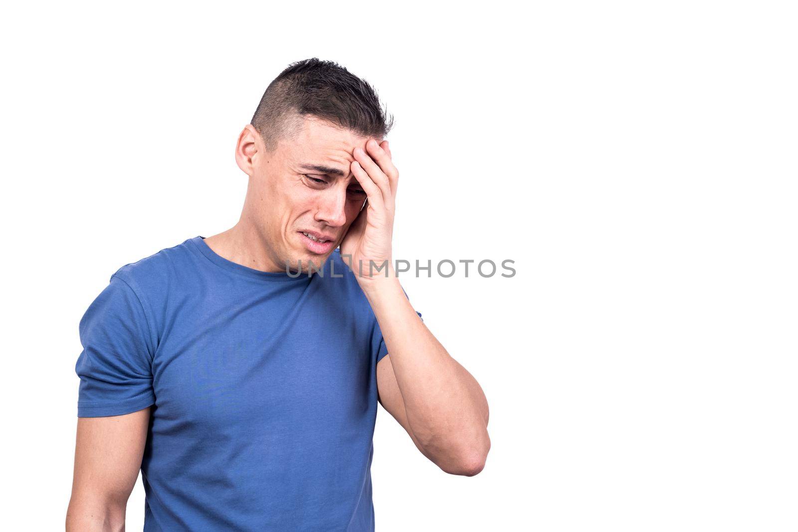 Studio photo with white background of a man with his hand on his head crying