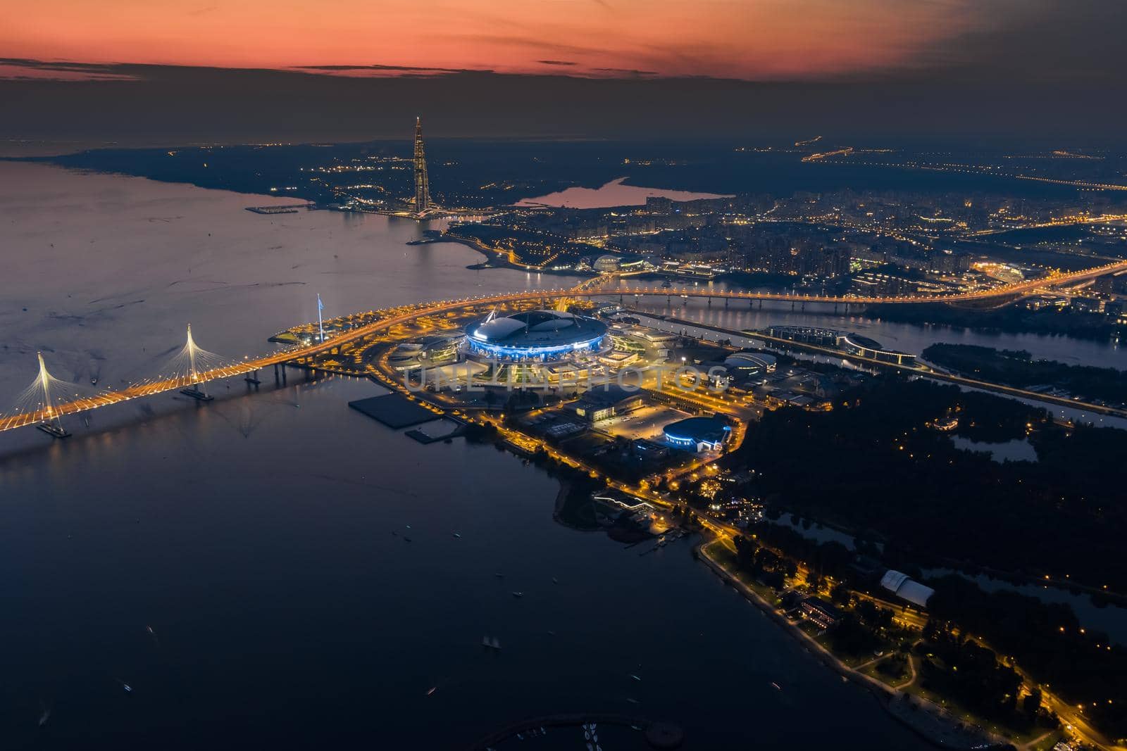 Russia, St. petersburg, 17 August 2022: A picturesque sunset over the sights, the Gazprom Arena football stadium, the highest skyscraper in Europe Lakhta and a cable-stayed bridge, illuminated highway. High quality photo