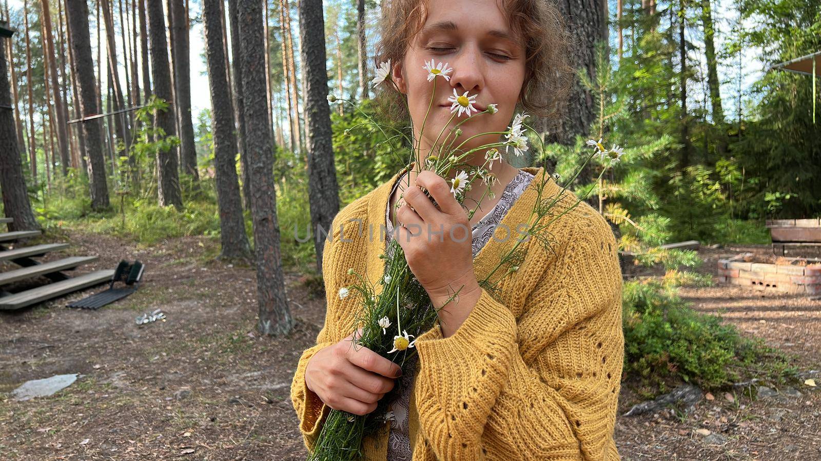 Beautiful woman smelling flowers in the woods by Varaksina