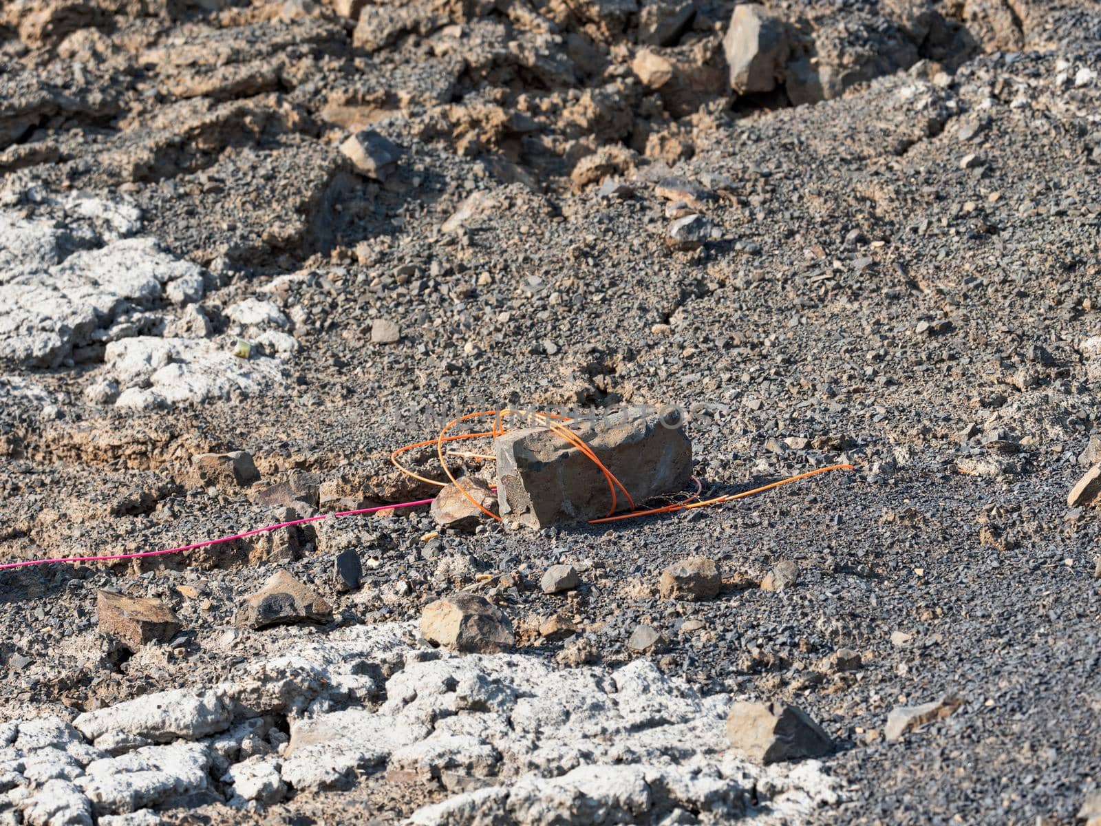 Explosive works in quarry , drilled rocks stuffed with explosives and colorful ignition lines. Holes for explosive filing in basalt mine