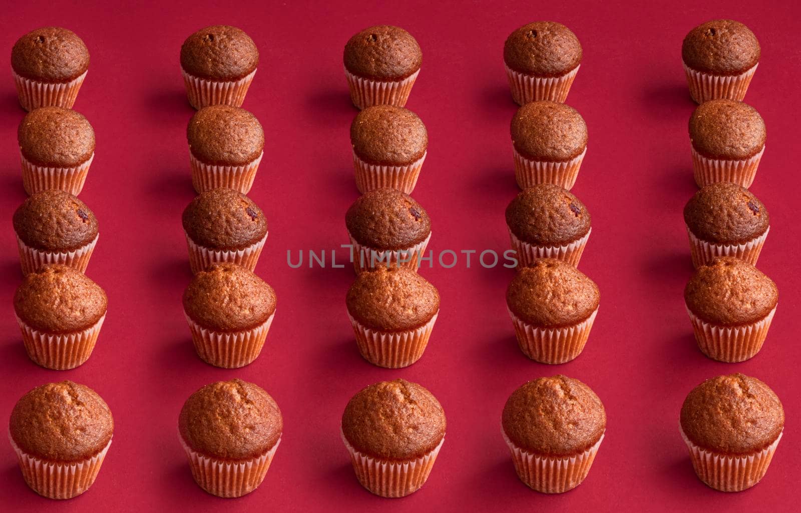 vanilla mini muffins on a red background. Place for your text. Cupcake pattern. Muffin texture. Background. High quality photo