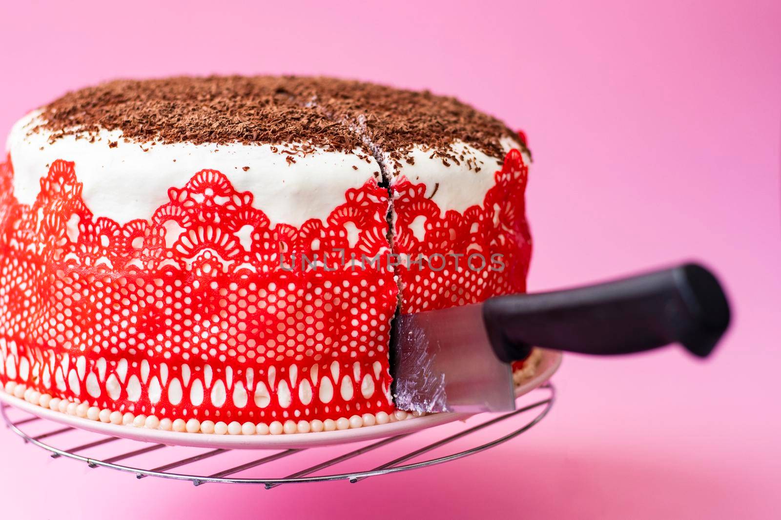 beautiful homemade cake on a stand with a knife. The birthday cake is ready to be cut. delicious bright cupcake decorated with lace and beads. High quality photo