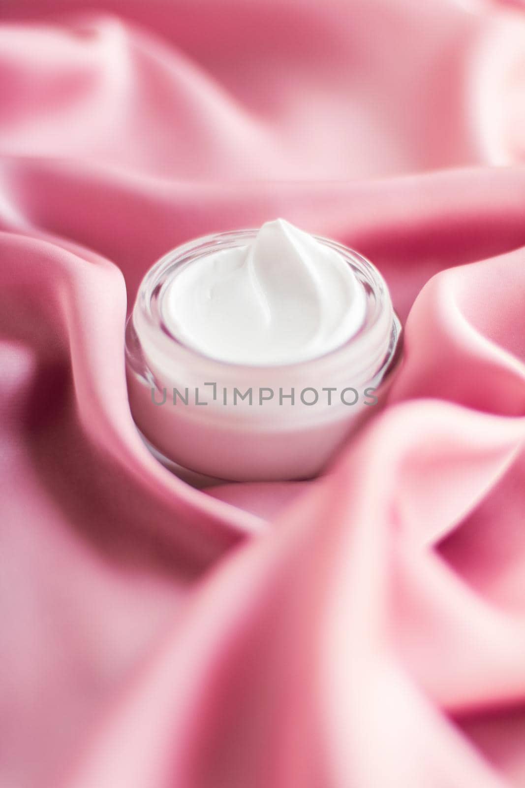 Beauty, anti-age cosmetics and skincare concept - Luxury face cream jar on a soft pink silk