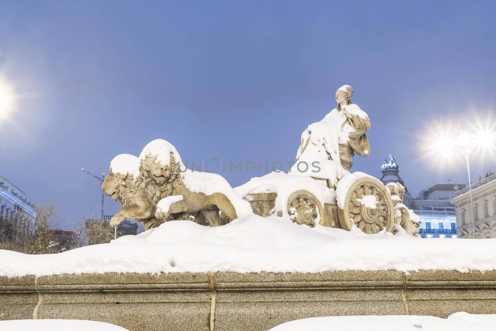Plaza de la Cibeles in Madrid on a cold winter night after a heavy snowfall.