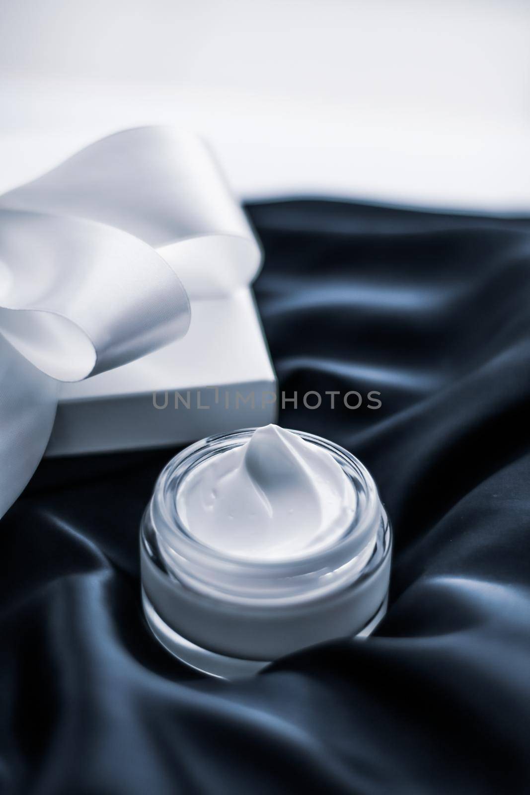 Beauty, cosmetics and skincare styled concept - Luxury moisturizing cream and a gift box on black silk