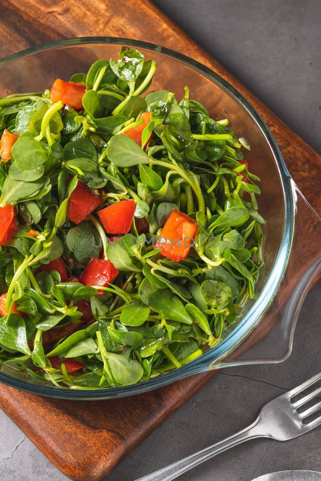 Purslane salad with tomatoes in a glass bowl. Healthy eating concept by Sonat