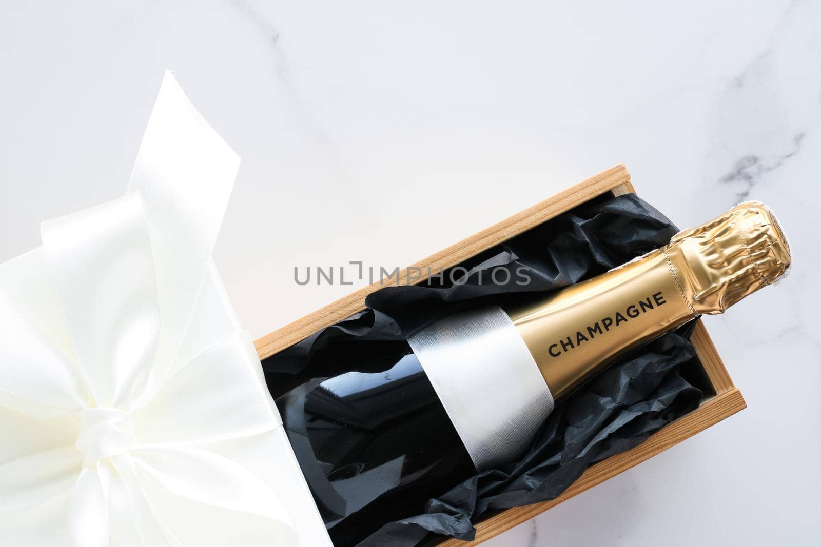 Wedding celebration, lifestyle and luxury present concept - A champagne bottle and a gift box on marble