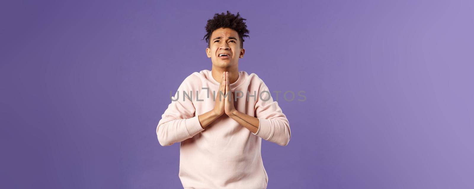 Portrait of young distressed and devestated hispanic guy pleading to god, have difficult situation, praying with hands clasped together over chest, look up supplicating desperate.