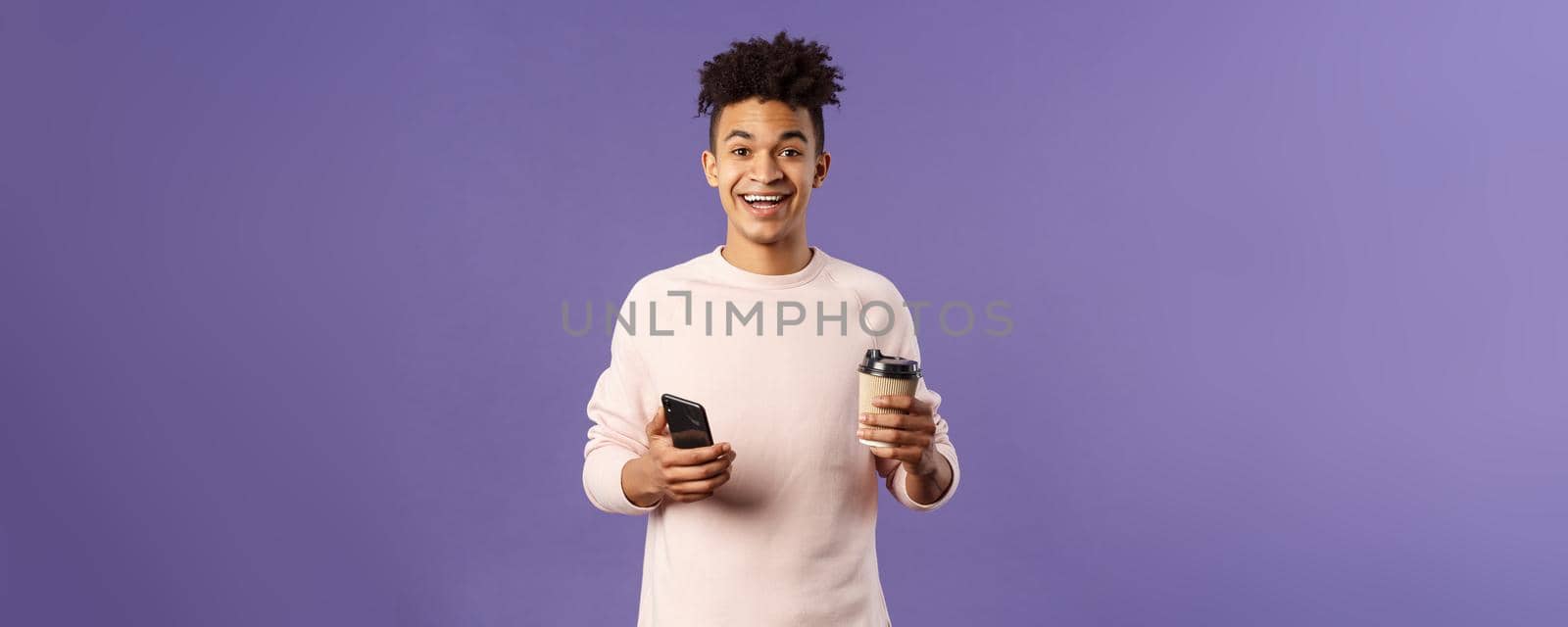 Waist-up portrait of happy enthusiastic hispanic man with smartphone, hold mobile phone and drinking coffee from take-away cup in office cafe, discuss recent project coworkers and team by Benzoix