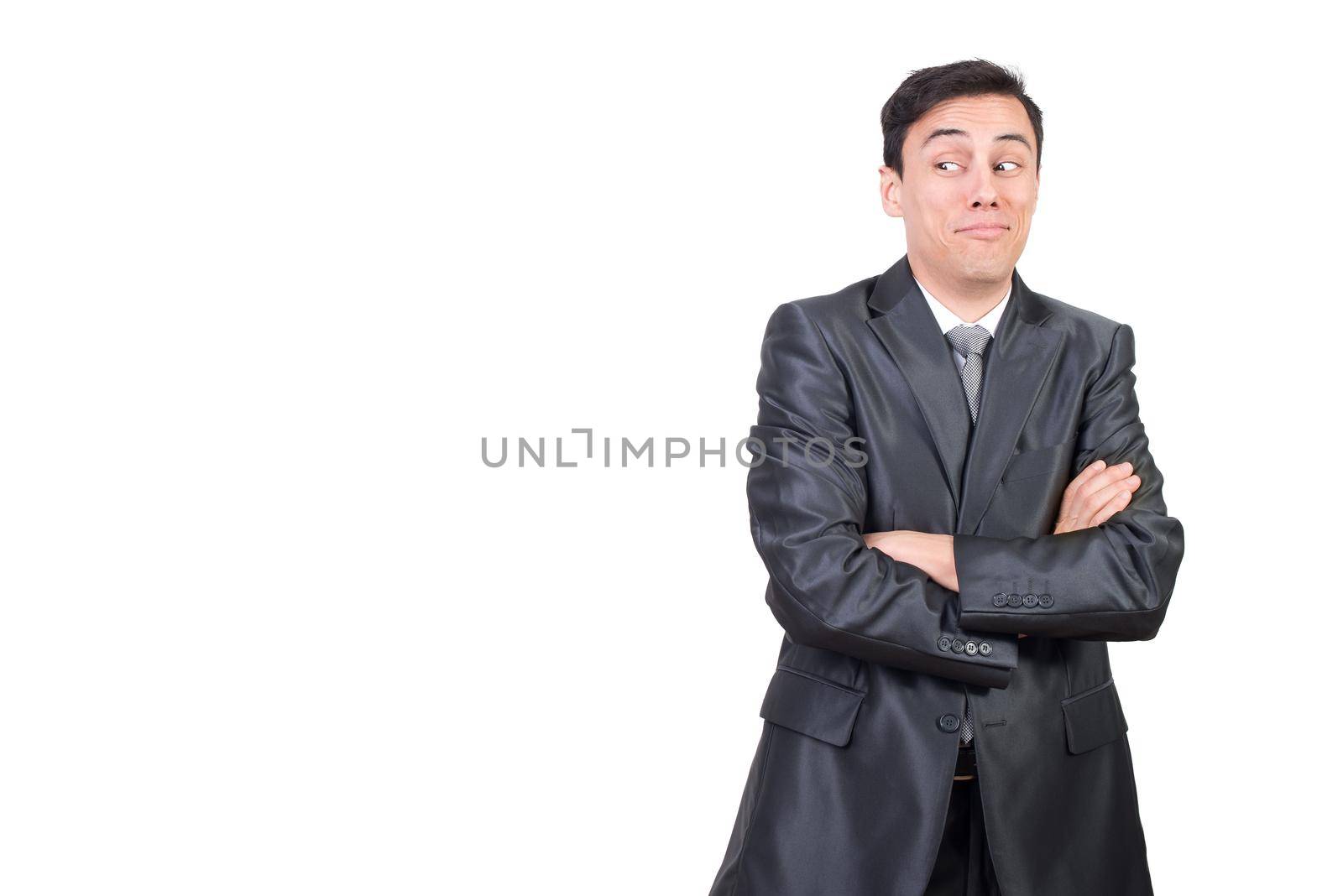 Mid shot of astonished male in formal suit looking aside while standing with crossed arms isolated on white background in studio