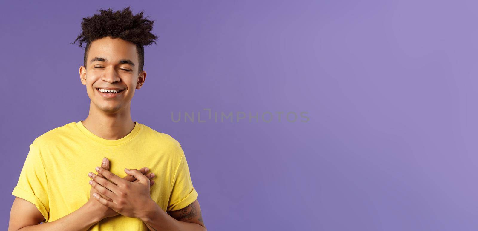 Close-up portrait of happy, upbeat young dreamy guy, remember sweet memories, hold hands on heart, smiling touched and delighted, close eyes grinning, recall romantic moment by Benzoix