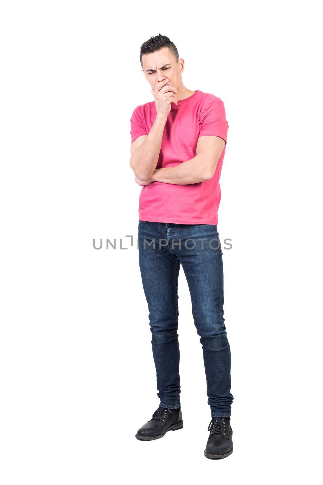 Full body of pensive male model in casual outfit touching chin while showing expression of confusion on white background