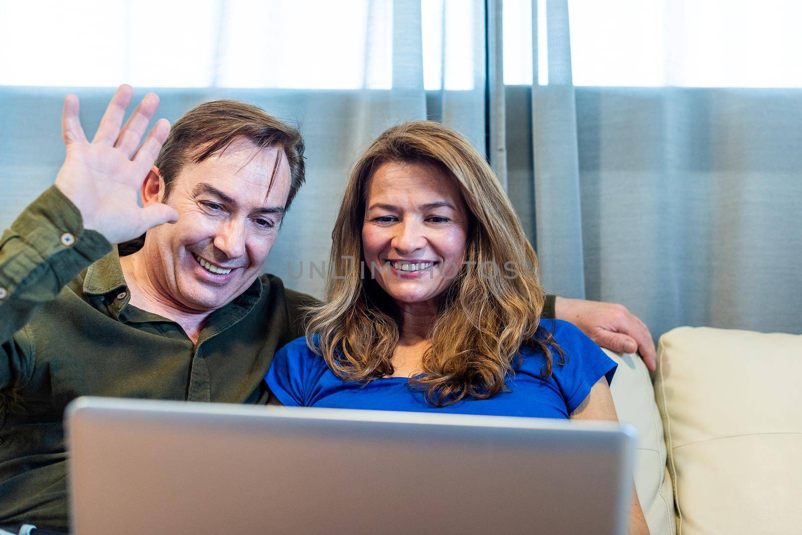 Smiling mature man and woman talking on video call with laptop. High quality photo
