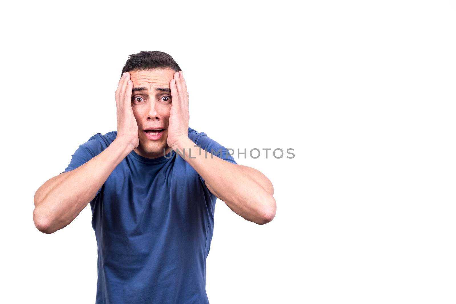 Studio portrait with white background of a man with hands on the face and expression of panic