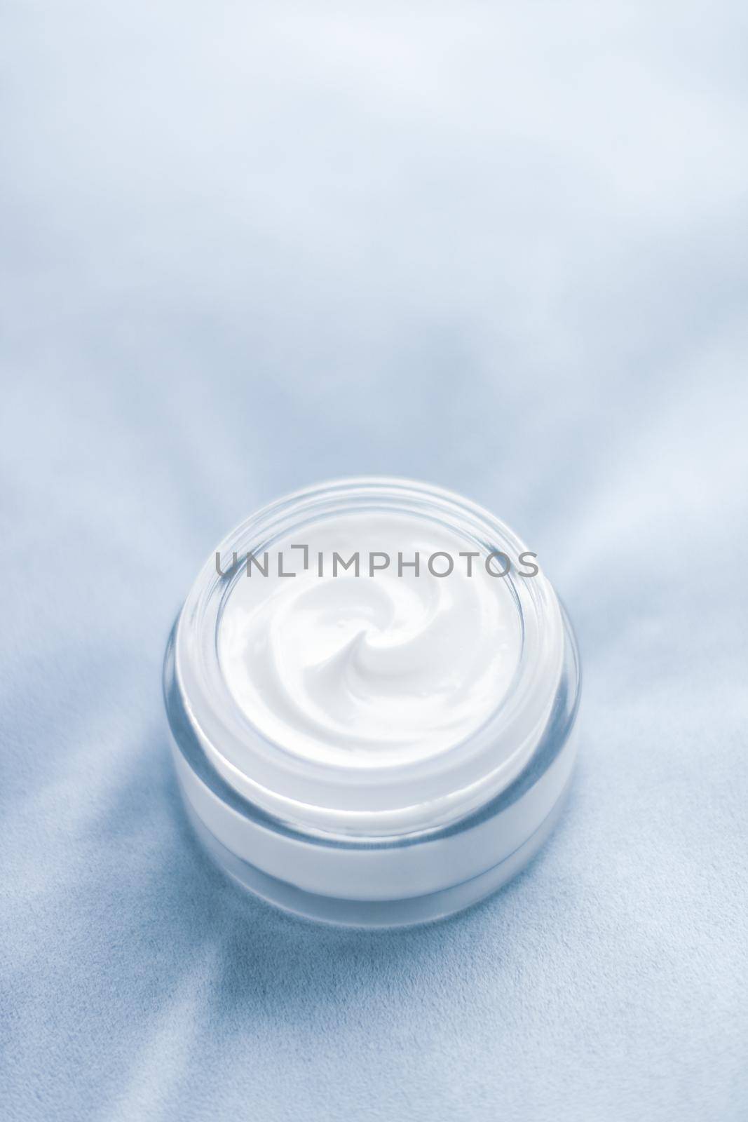 Beauty, anti-age cosmetics and skincare concept - Luxury face cream jar on blue silk