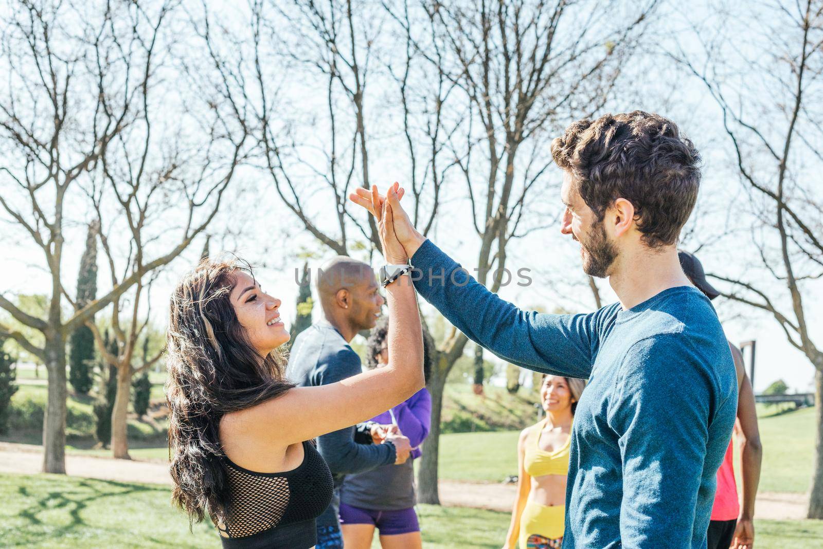 A girl and a boy runners hit the palms of their hands as a sign of success after a workout. Selective focus.