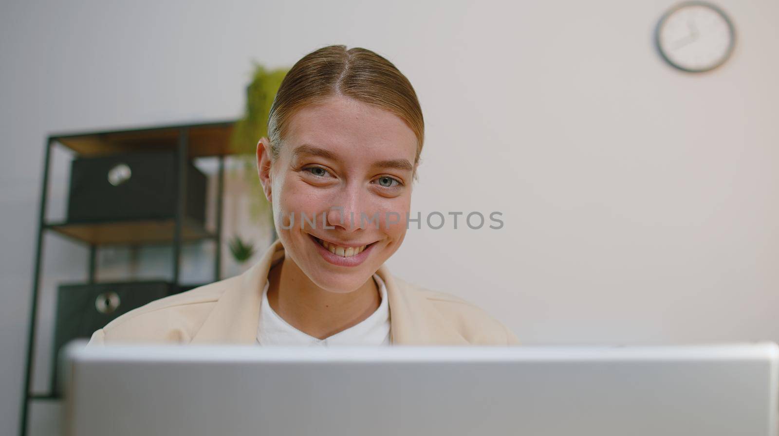 Close-up portrait face businesswoman freelancer at office workplace, working on laptop computer. Manager freelancer woman works on notebook, sends messages makes online purchases watching movies