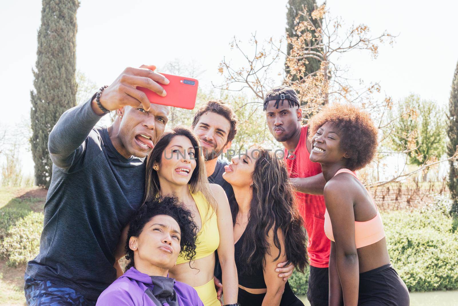 Group of runners taking a selfie in a park. Making funny faces. Horizontal framing.