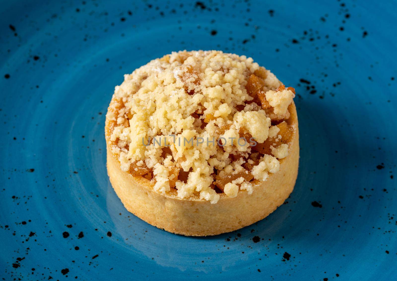 Freshly baked single portion apple pie on a blue porcelain plate by Sonat