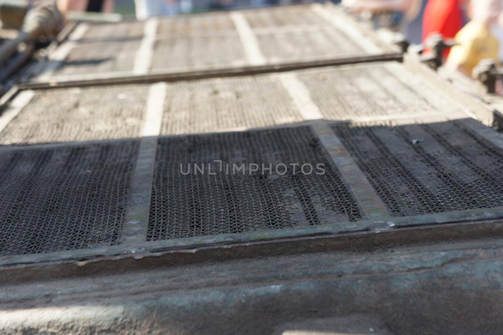 Lattice texture close up. Holes of grey metal plate with round regular holes texture background. Military Texture. Lattice construction on military vehicles in green protective colors