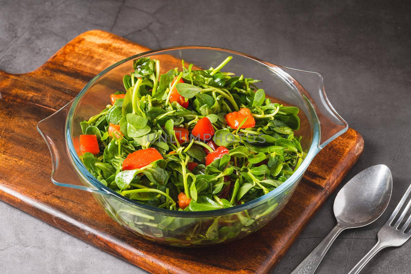 Purslane salad with tomatoes in a glass bowl. Healthy eating concept