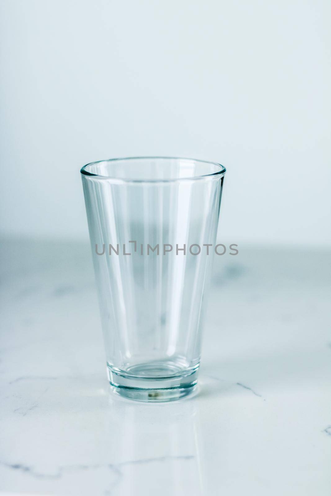 Glassware, washing and purity concept - Clean empty glass on marble table