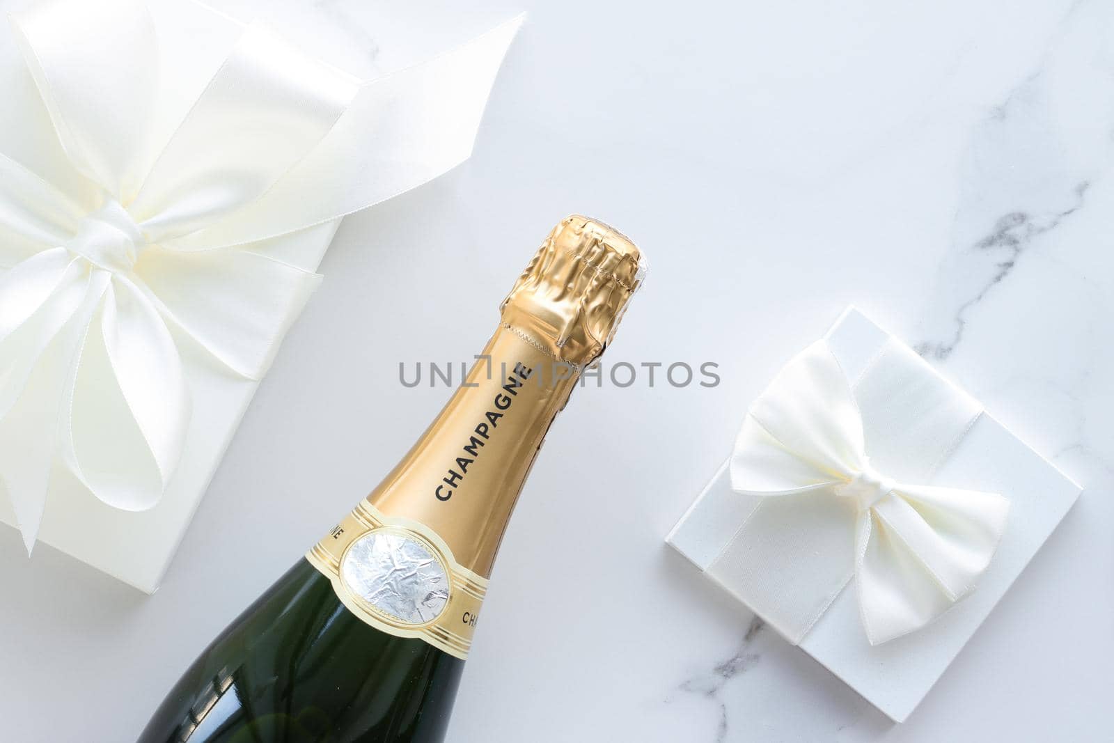 Wedding celebration, lifestyle and luxury present concept - A champagne bottle and a gift box on marble