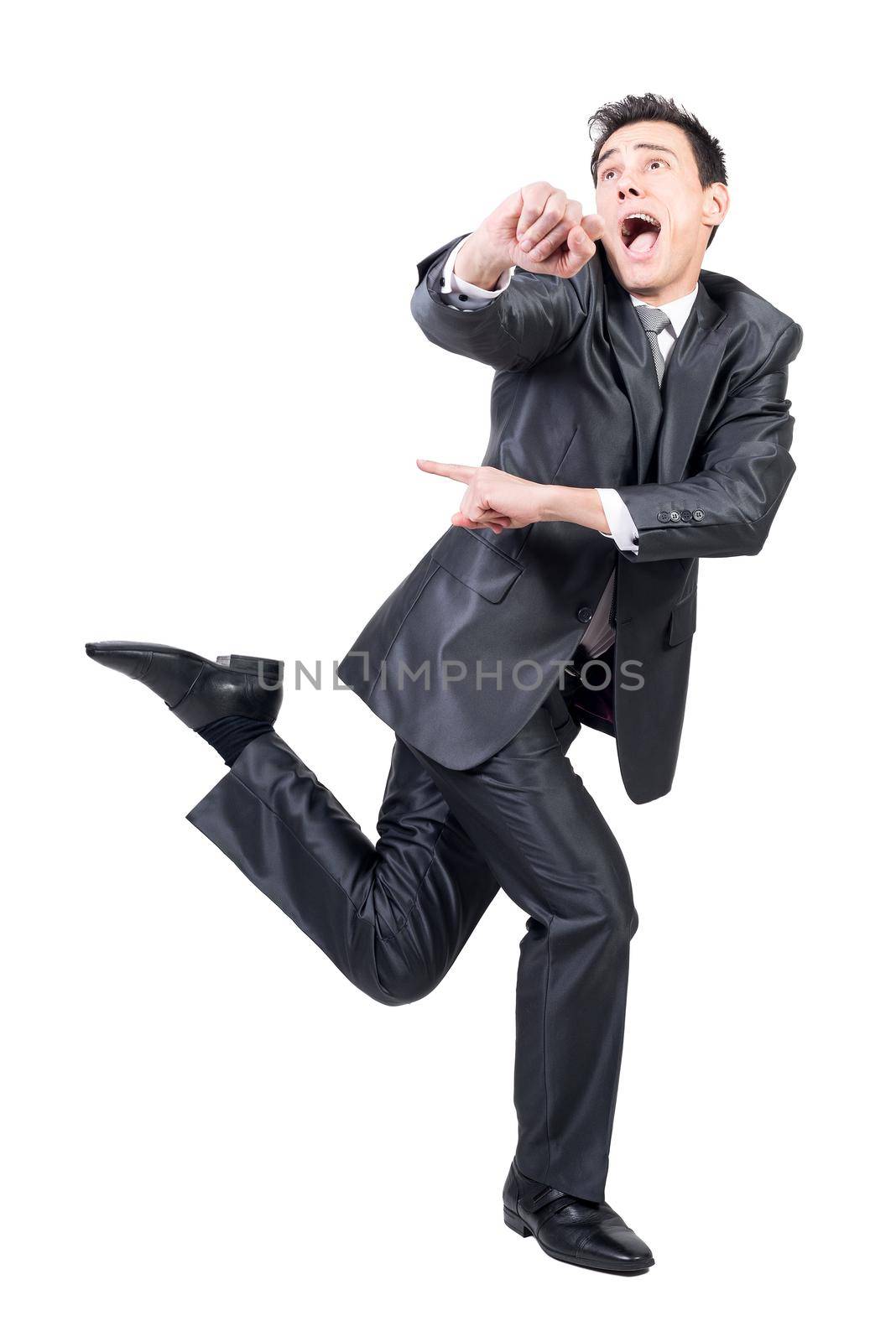 Full body of crazy young male entrepreneur with dark hair in formal outfit shouting and looking away while running against white background