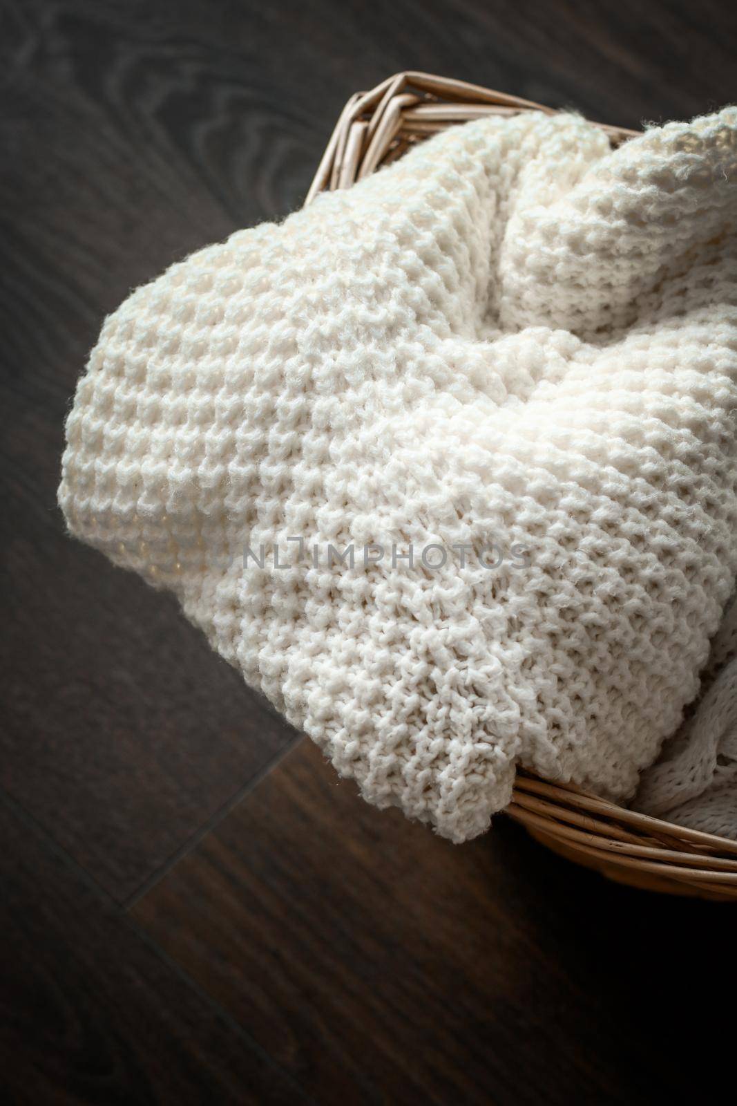 Knitted winter clothes in a basket by Anneleven