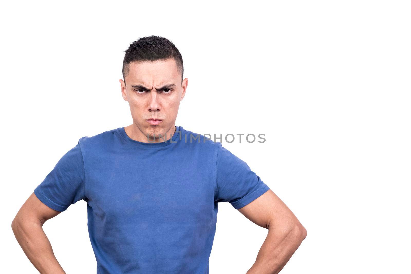 Studio portrait of a man looking at the camera with a scowl on his face and an angry expression.