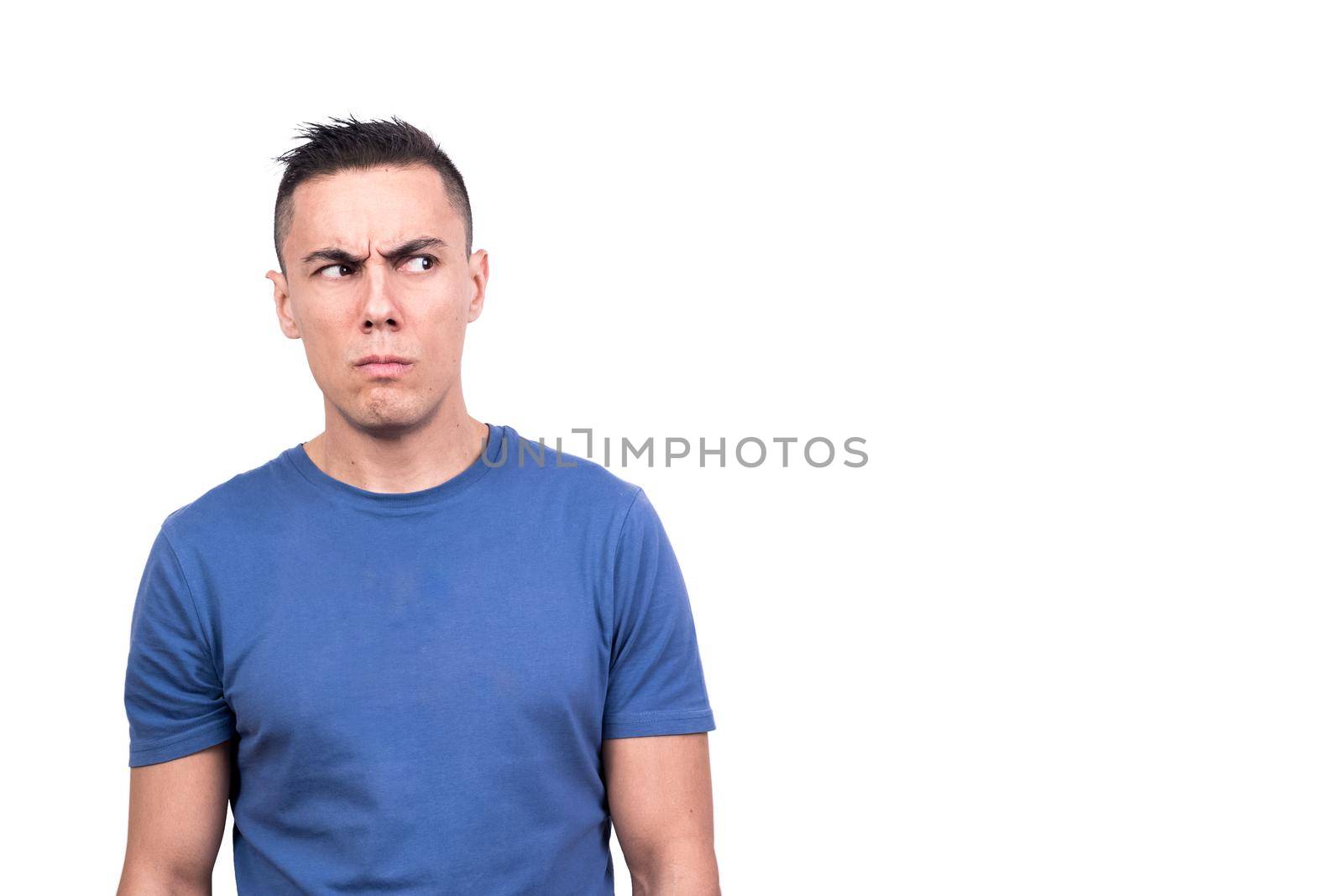 Studio photo with white background of a man looking to one side with a distrustful expression