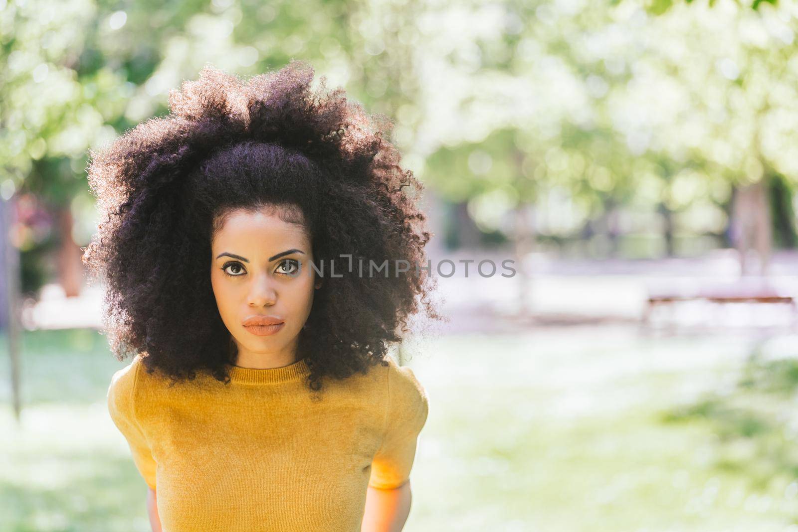 Portrait of nice afro girl in a garden. Close up. Selective focus.