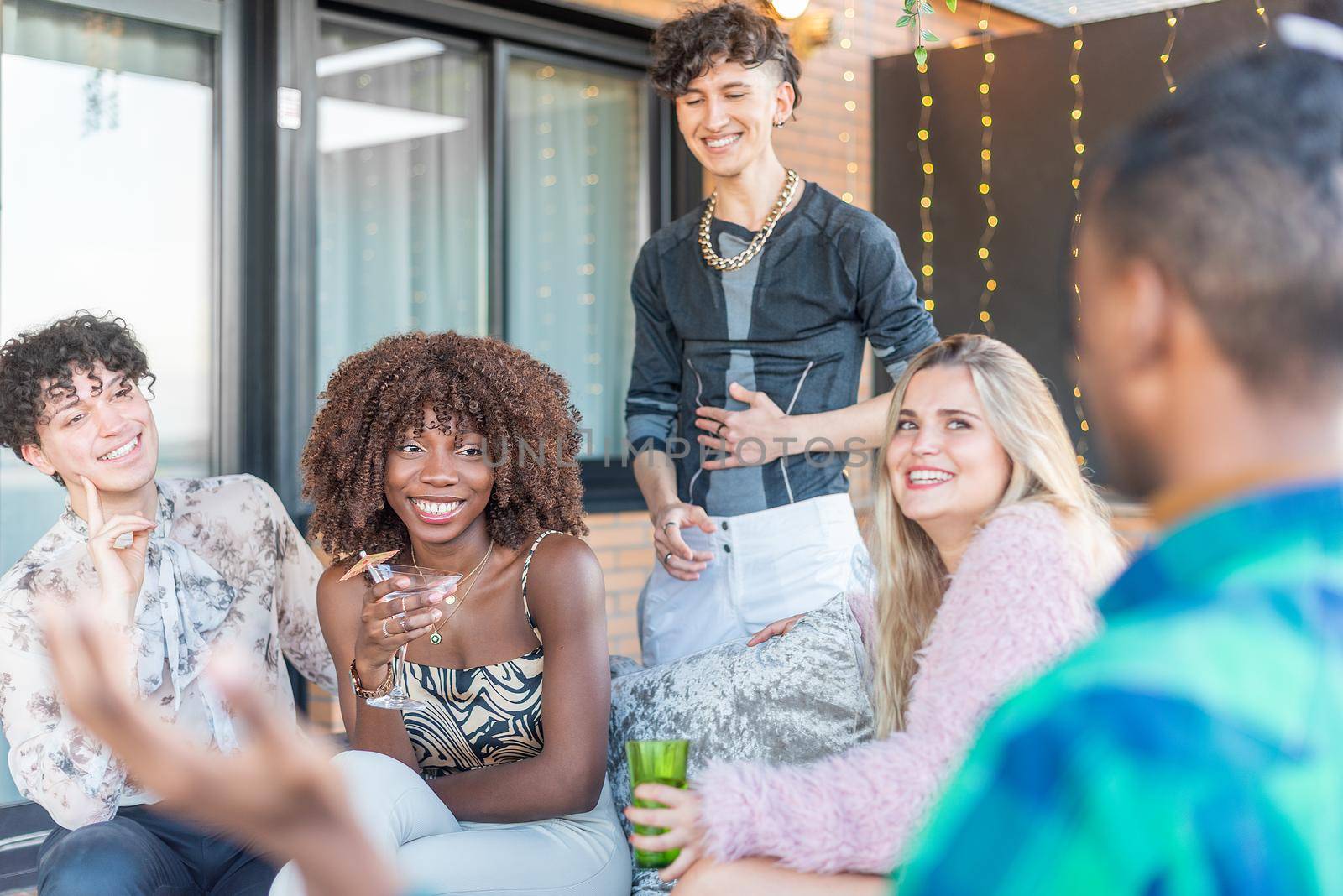 A group of a multi-ethnic friends celebrating New Year's Eve on a terrace.