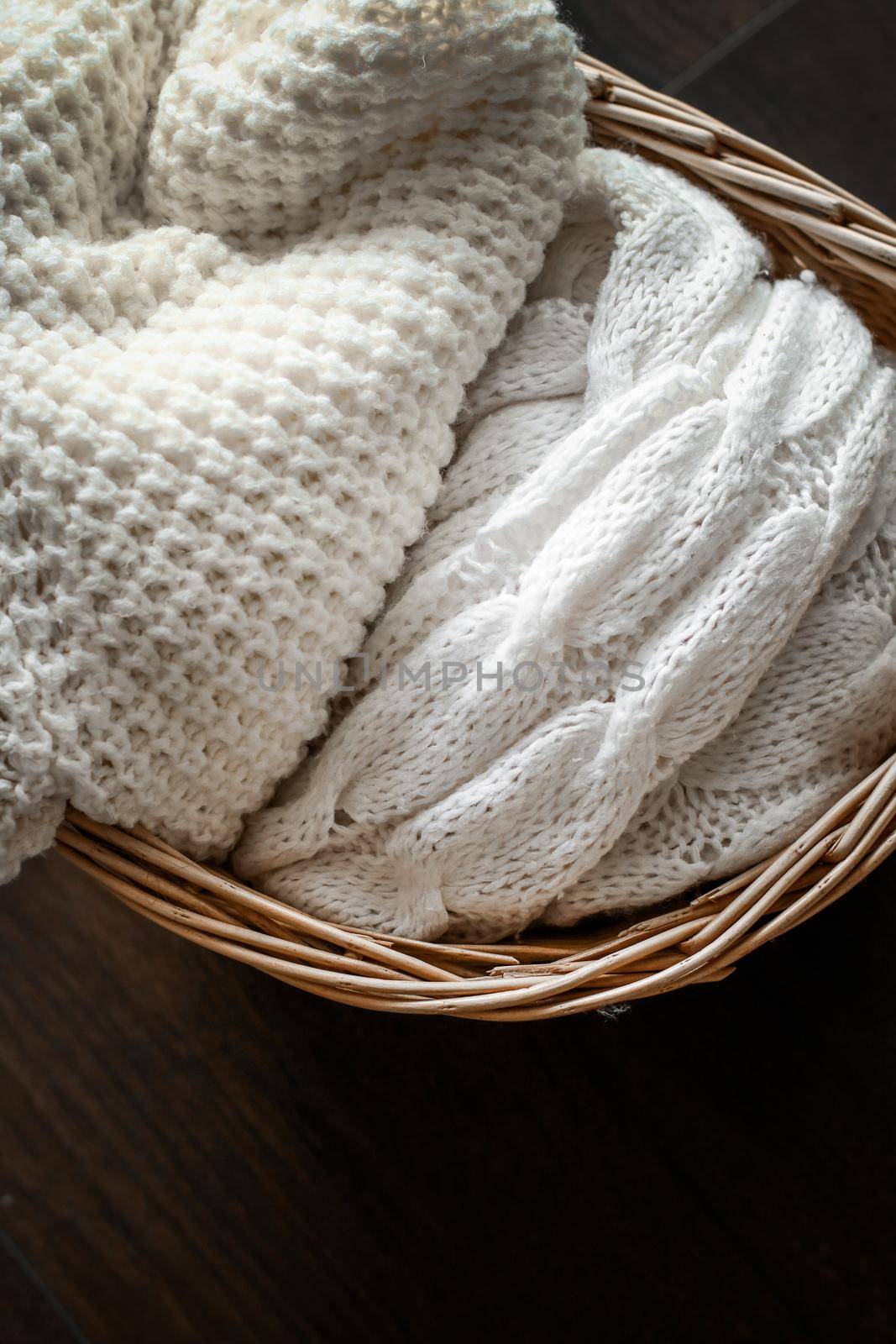 Knitwear, fabric textures and rustic lifestyle concept - Knitted winter clothes in a basket