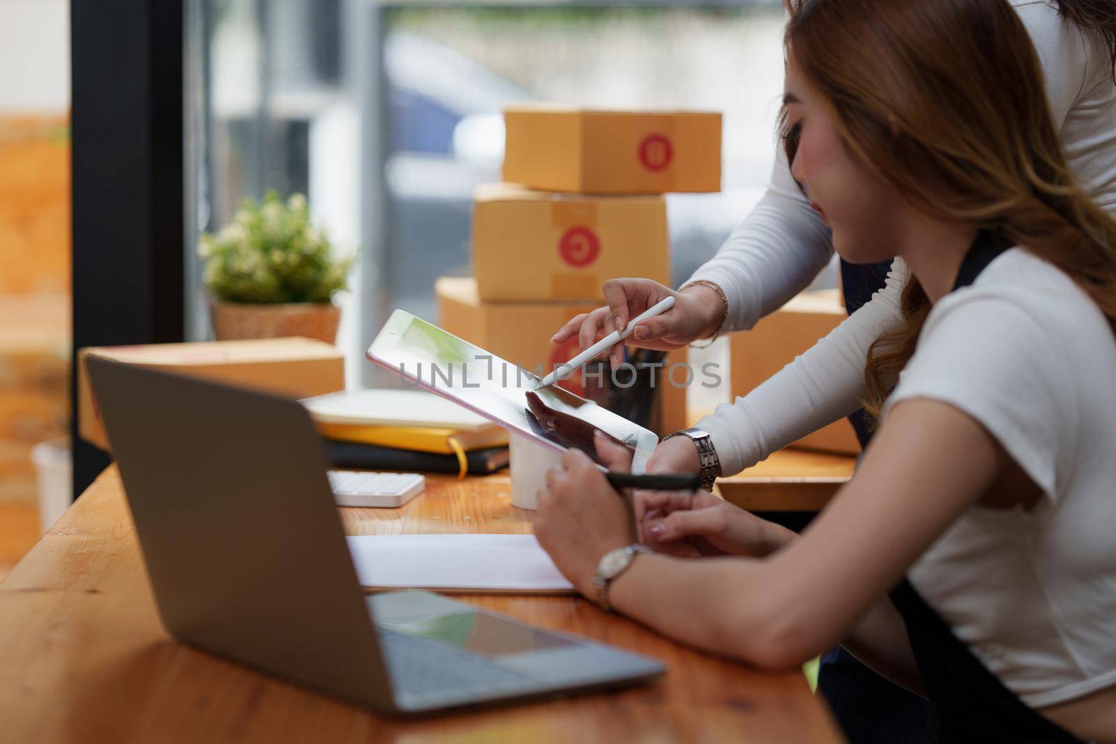 Asian SME business woman with partner working at home office. online shopping concept.