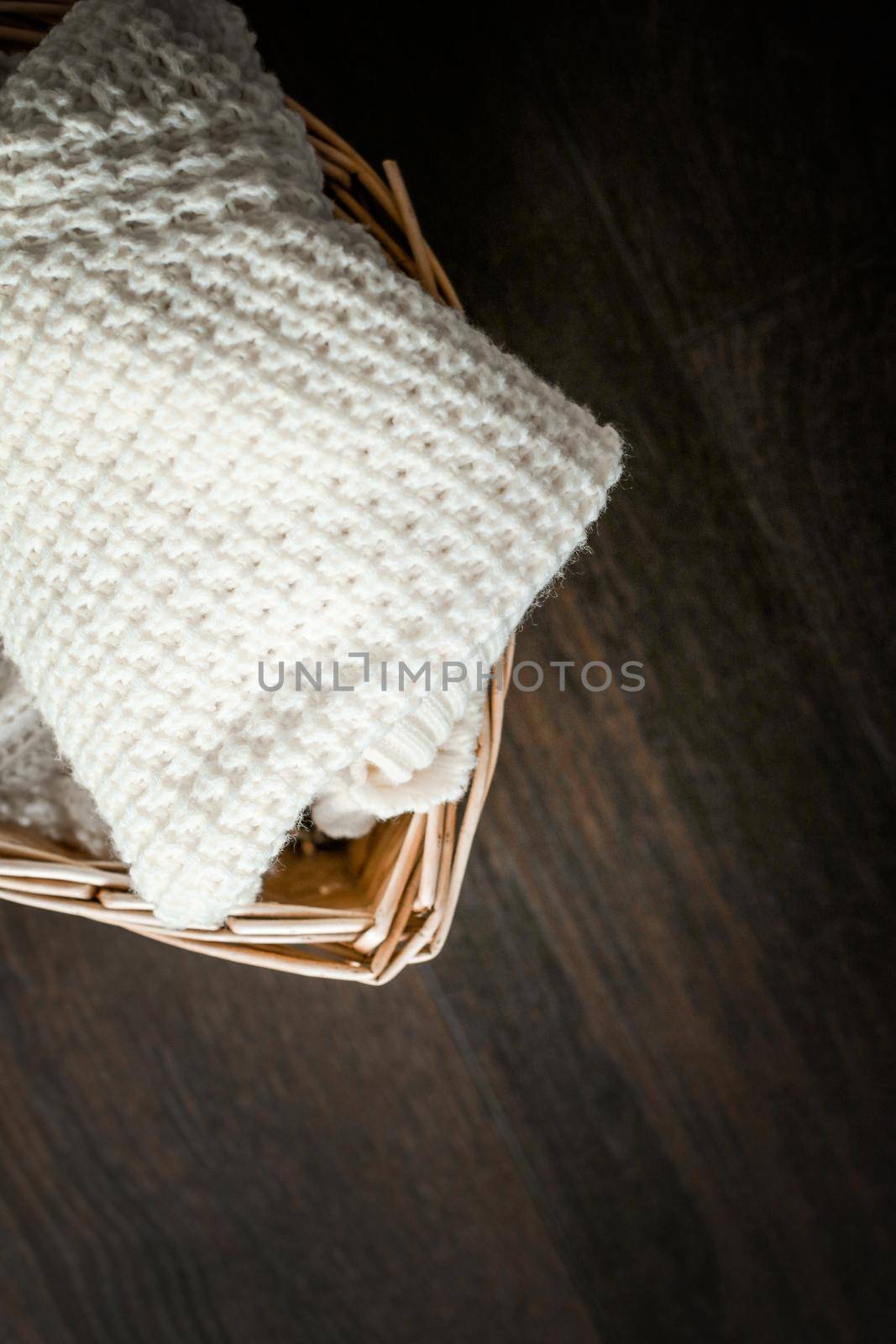 Knitted winter clothes in a basket by Anneleven