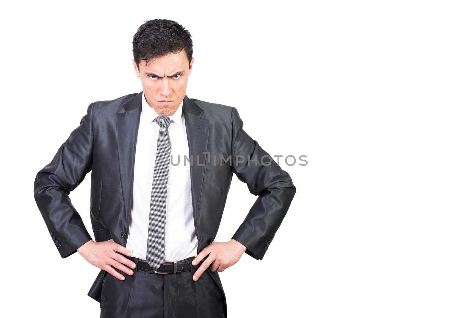 Dissatisfied male manager in formal suit standing with hands on waist and looking at camera with angry expression