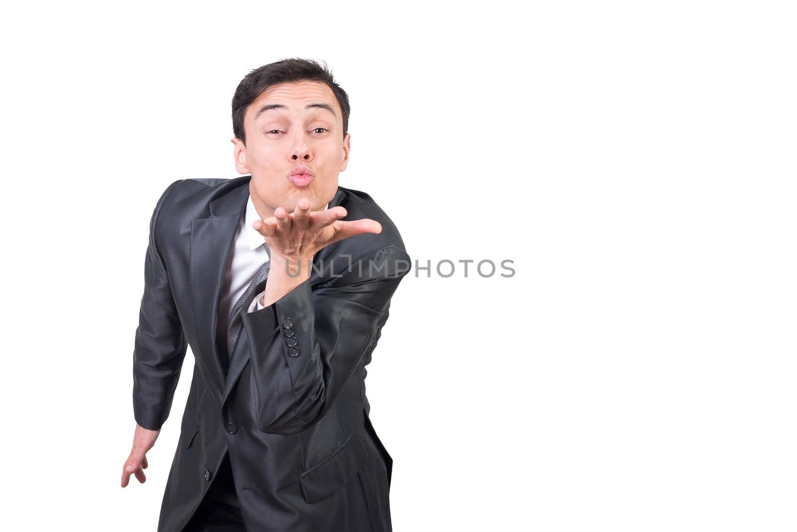 Mid shot of male in formal wear looking at camera while sending air kiss isolated on white background in studio