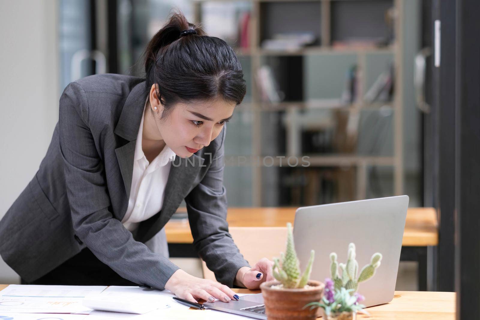 Portrait of Asian young female working on laptop at office.