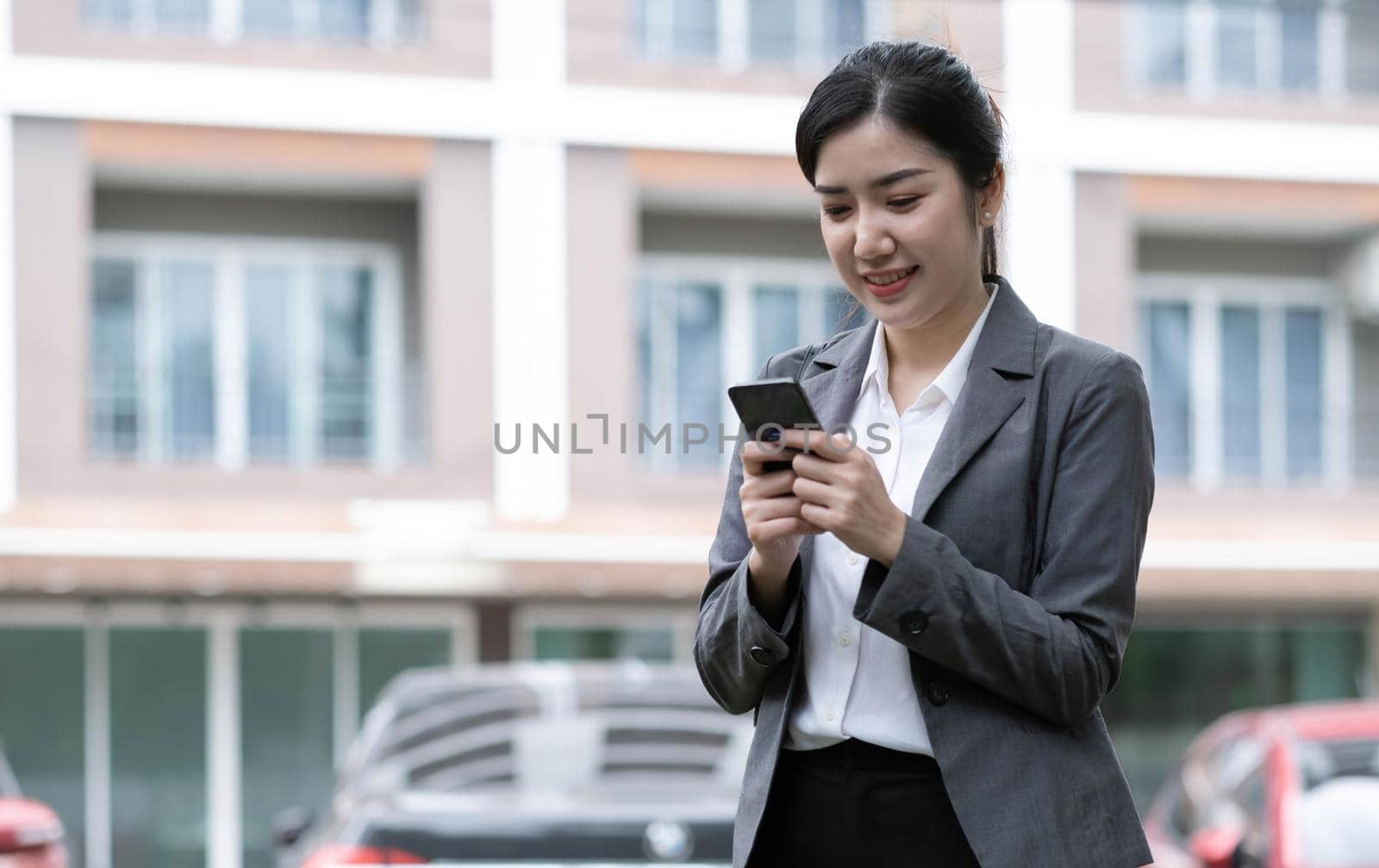 Portrait of a beautiful smiling woman using a mobile phone outdoors.