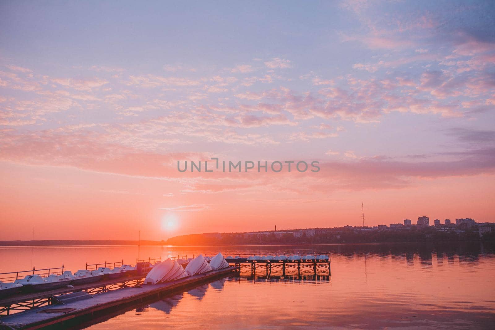 wooden pier with boats at sunset.