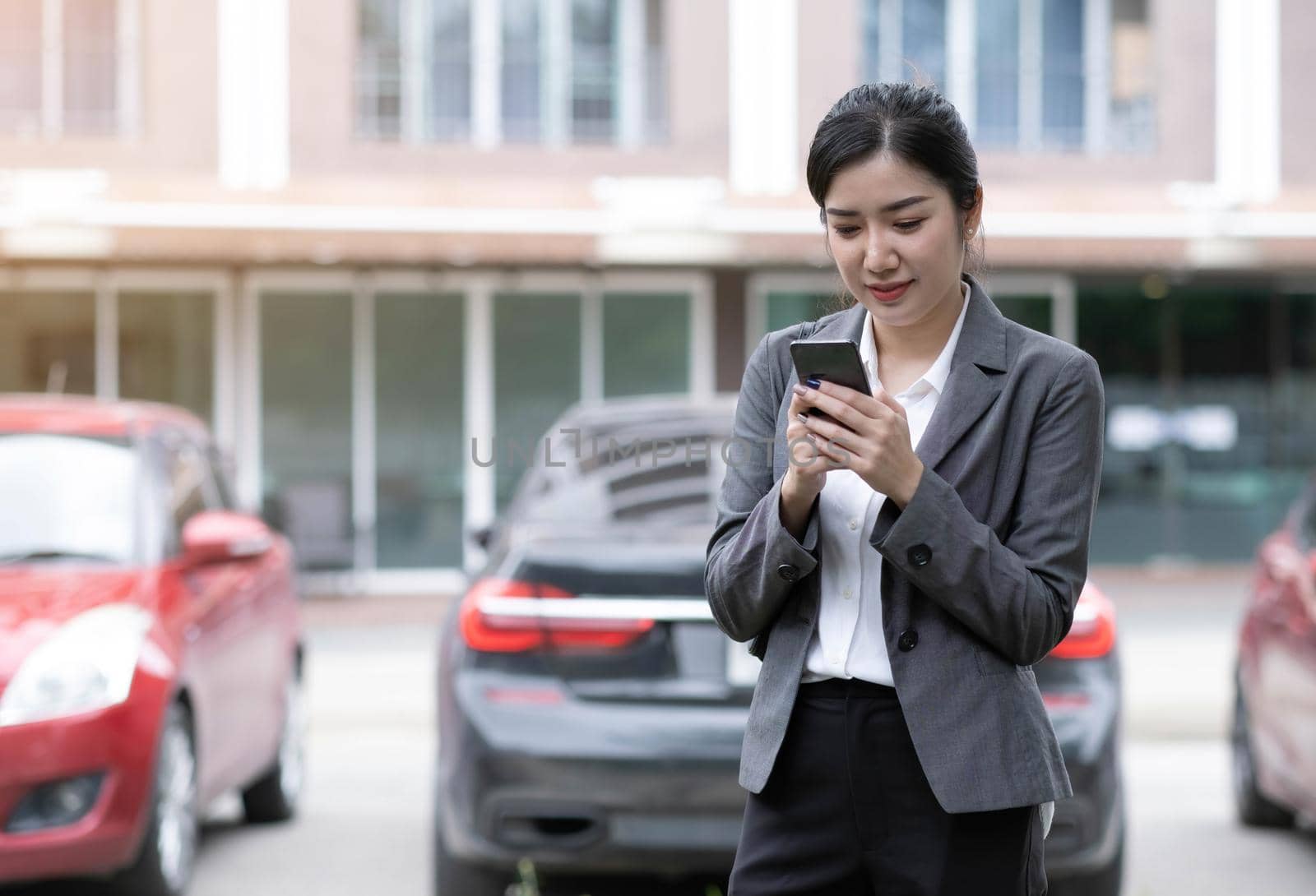 Portrait of a beautiful smiling woman using a mobile phone outdoors by wichayada