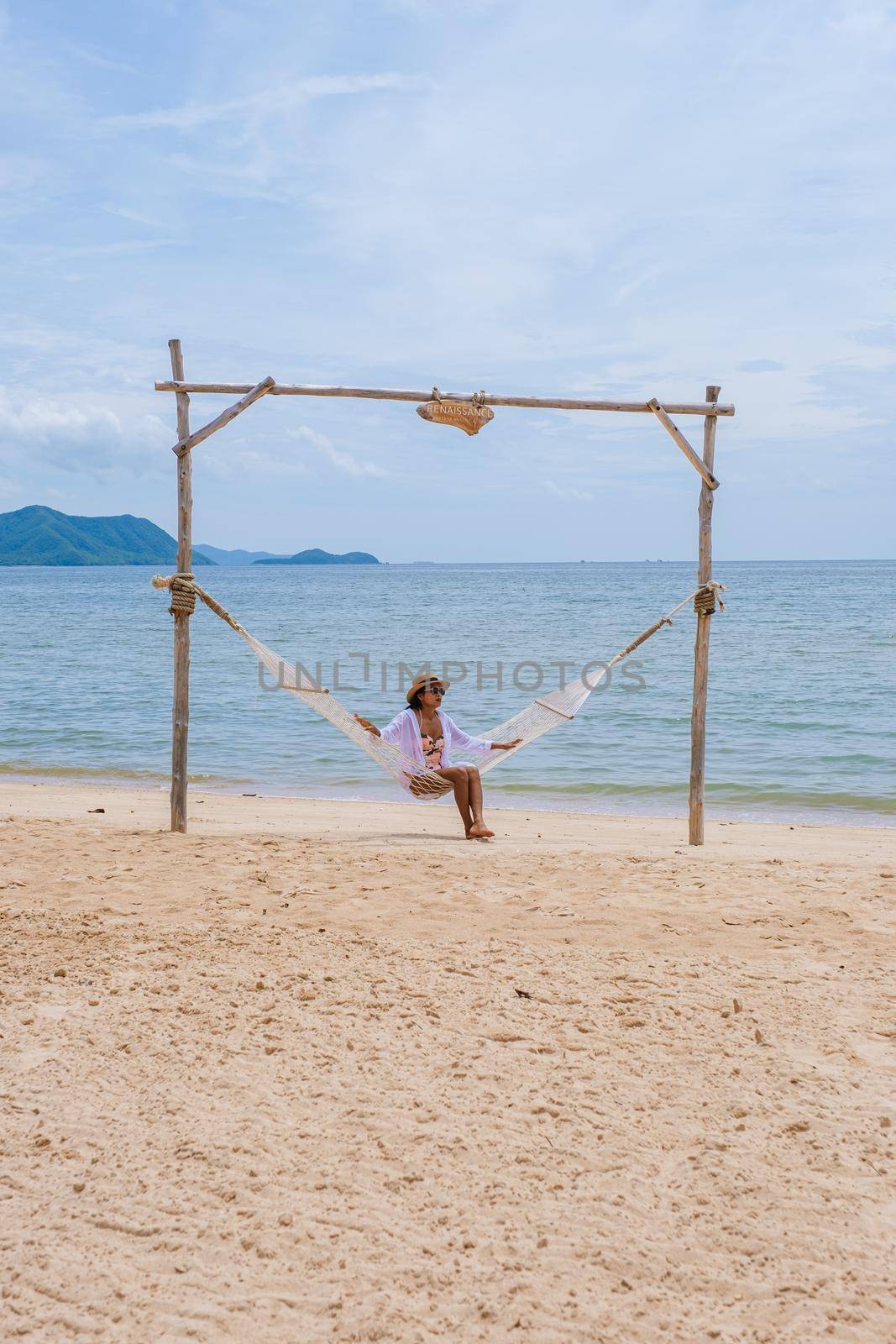 Women on a sunny day with a hammock on the beach in Pattaya Thailand Ban Amphur beach by fokkebok
