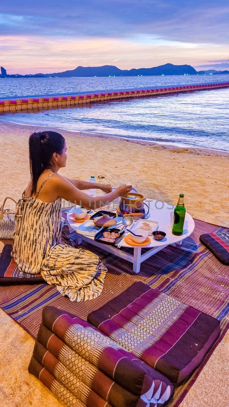 women bbq cooking noodle soup on the beach in Pattaya during sunset in Thailand Ban Amphur beach by fokkebok