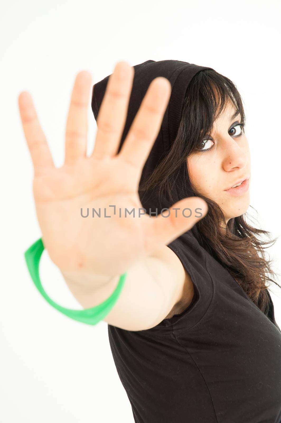 Modern pretty brunette girl with arm and palm extended for you to stop, on white background, close up